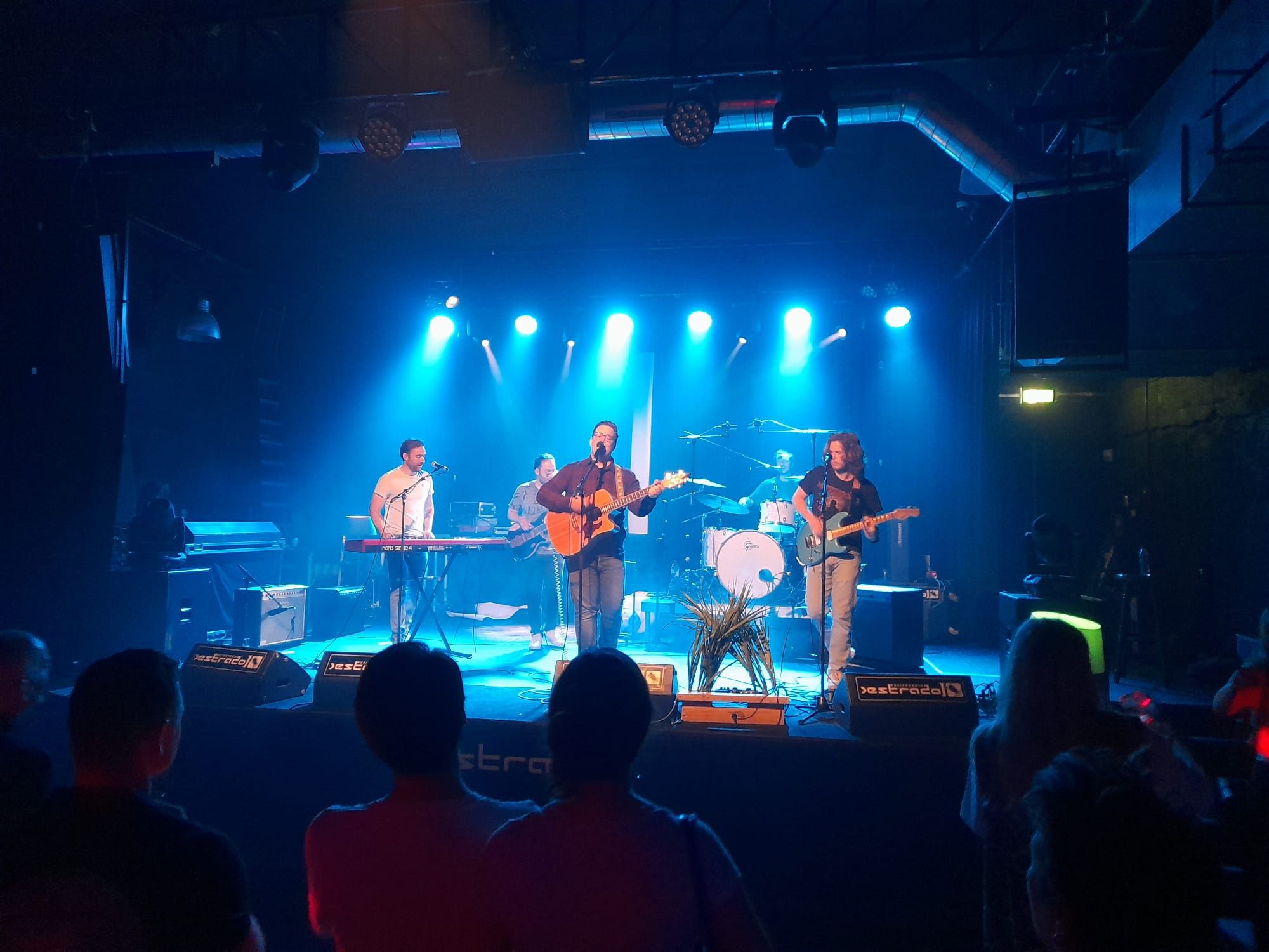 Landhuis & Caravan speelt live op een blauw verlicht podium